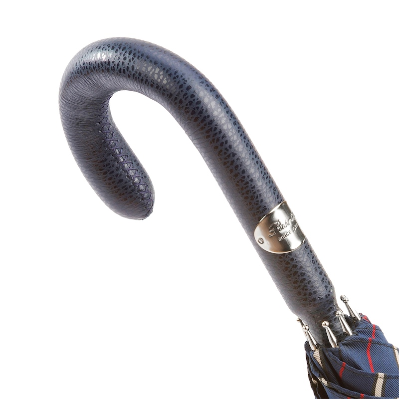Curved dark blue textured leather umbrella handle with a silver metal plate and folded navy umbrella fabric