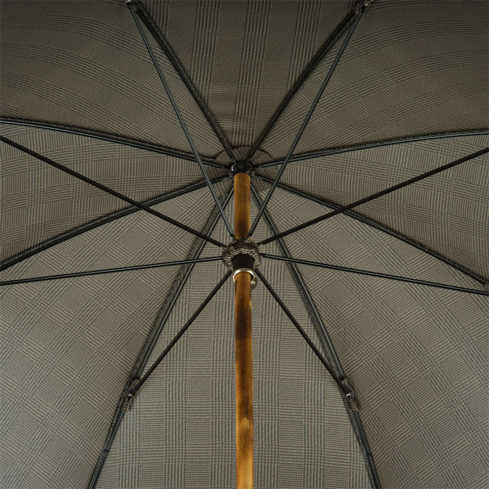 Close-up of umbrella underside showing wooden shaft and plaid patterned fabric with black ribs