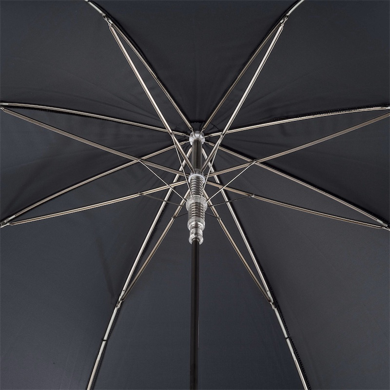 Close-up view of black umbrella's metal ribs and central shaft mechanism