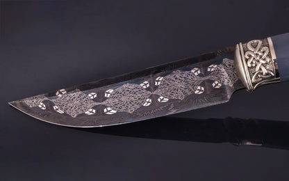 Decorative knife with intricate patterns on a dark background